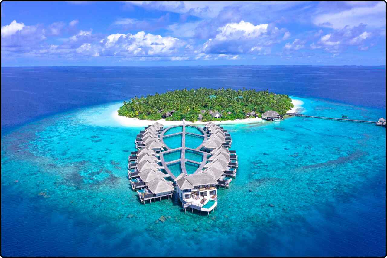 Stunning aerial shot of the Outrigger Island Resort at Konotta, nestled in the clear blue sea of the Maldives.